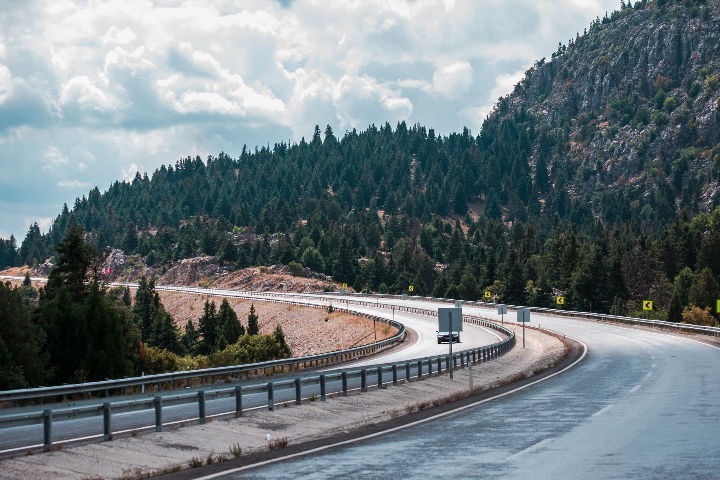 A winding highway through a pine and rock hillside, near our windshield replacement Rockerville SD service area